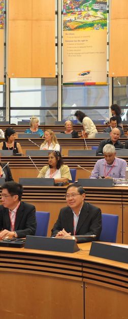 An audience seated in a large council chamber