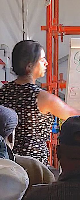 A facilitator writing on a flip chart in front of seated workers